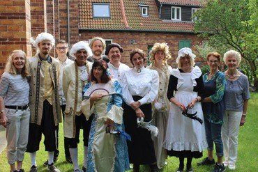 Gruppe von Personen in historischen und traditionellen Kostümen im Freien.
