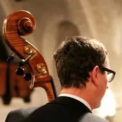 Rückenansicht eines Mannes, der Cello spielt, Schnecke und Wirbel im Fokus.